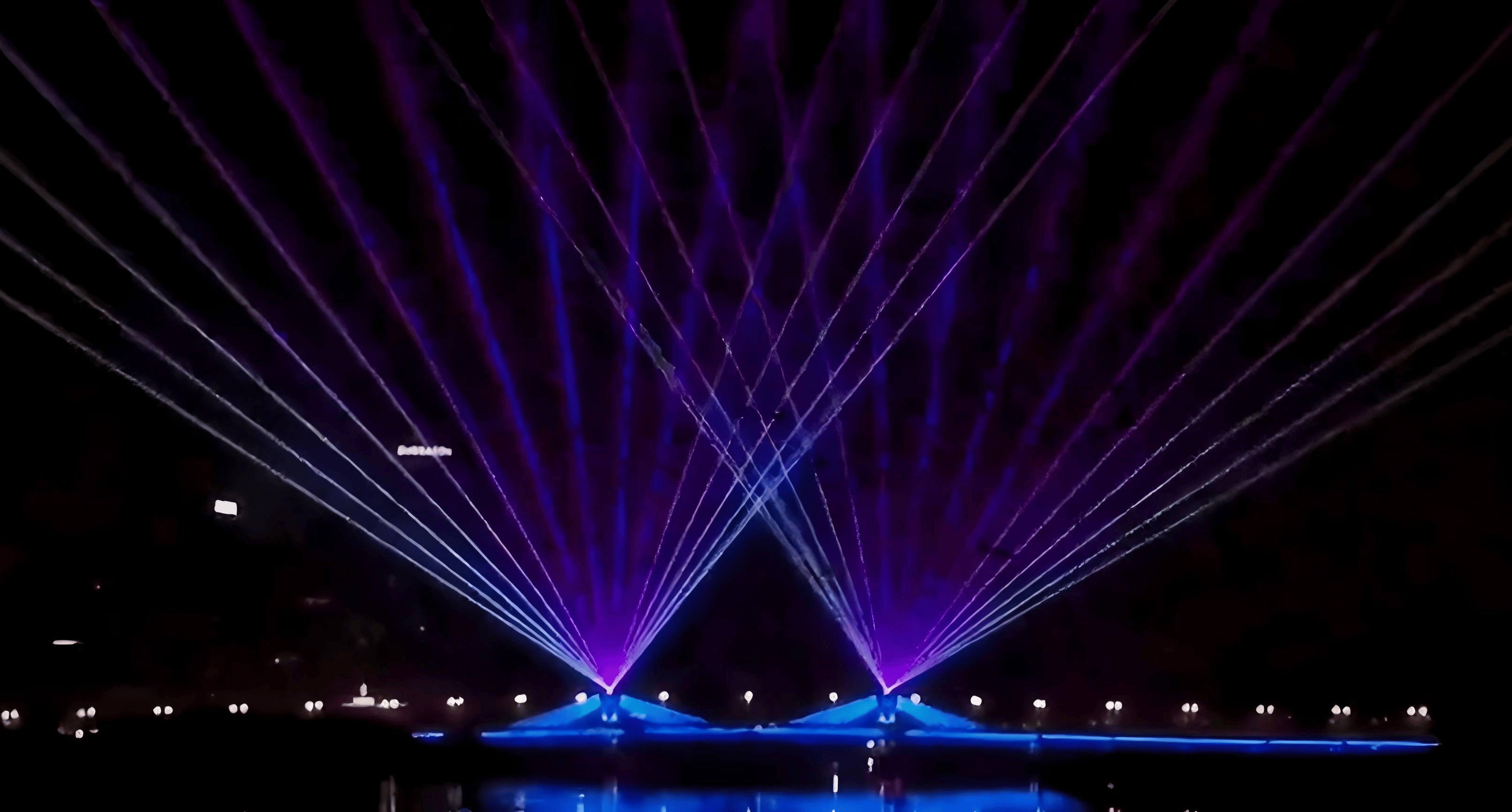 Colorful RGB laser beams crossing above the Cao'e River during the waterfront laser show in Shaoxing, China