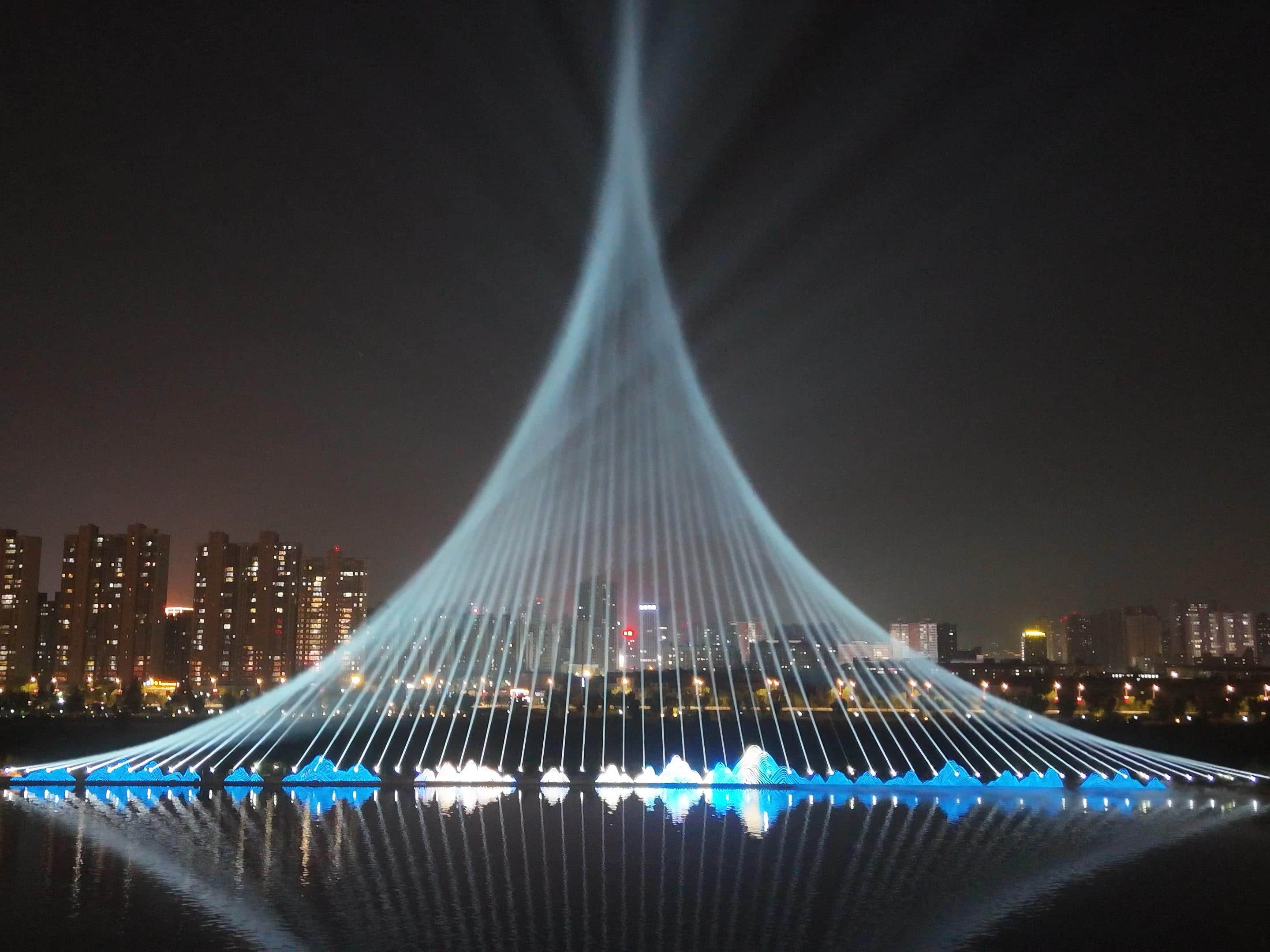 Xianyang Gudu Covered Bridge nighttime laser show featuring waterfront lighting, colorful laser beams and water effects