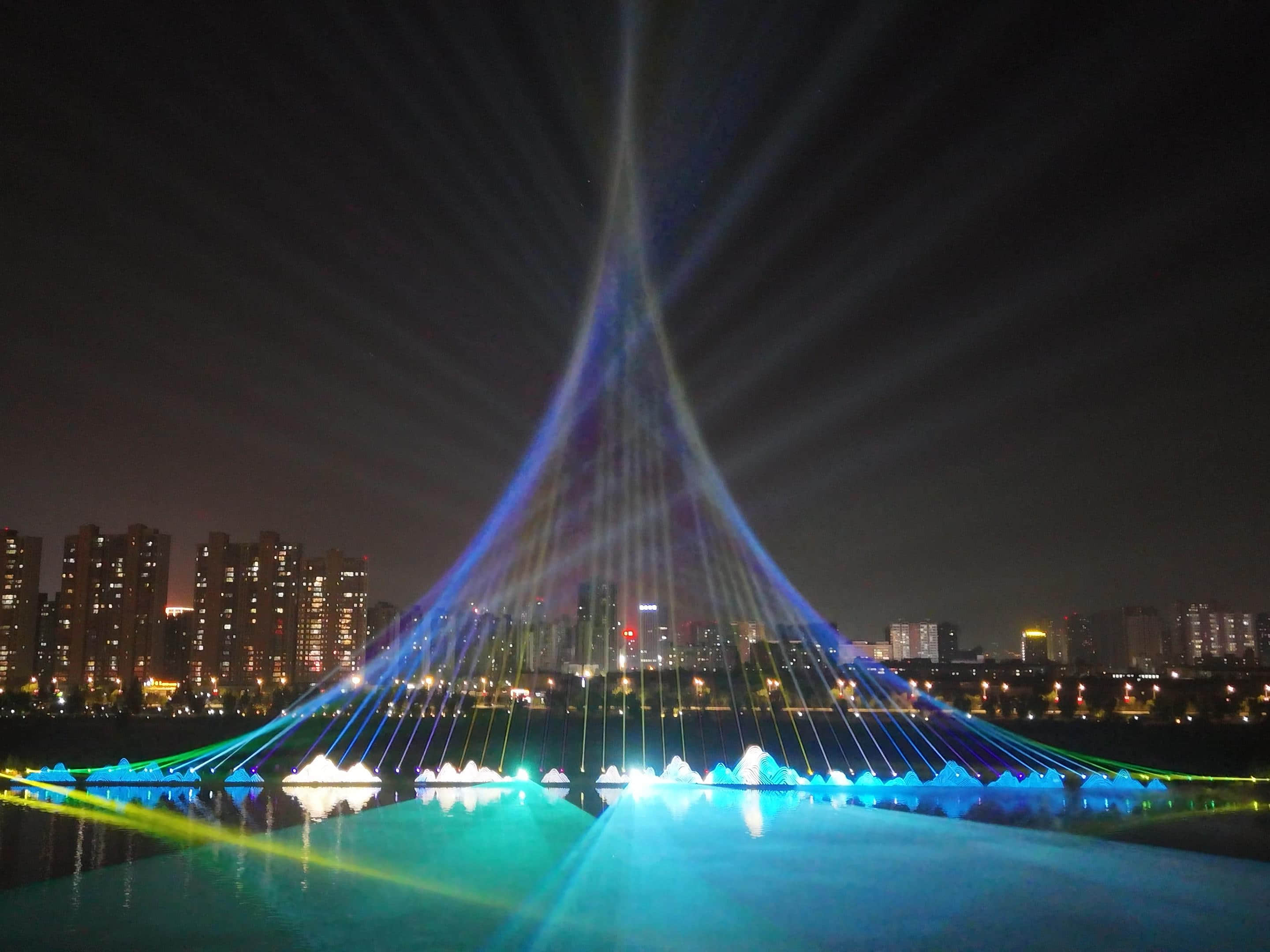 Xianyang Gudu Covered Bridge nighttime laser show featuring waterfront lighting, colorful laser beams and water effects