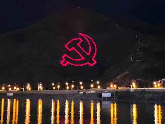 Outdoor laser text projection illuminating a mountainside during the Tibet anniversary celebrations