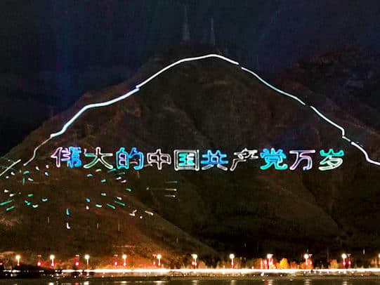 Outdoor laser text projection illuminating a mountainside during the Tibet anniversary celebrations