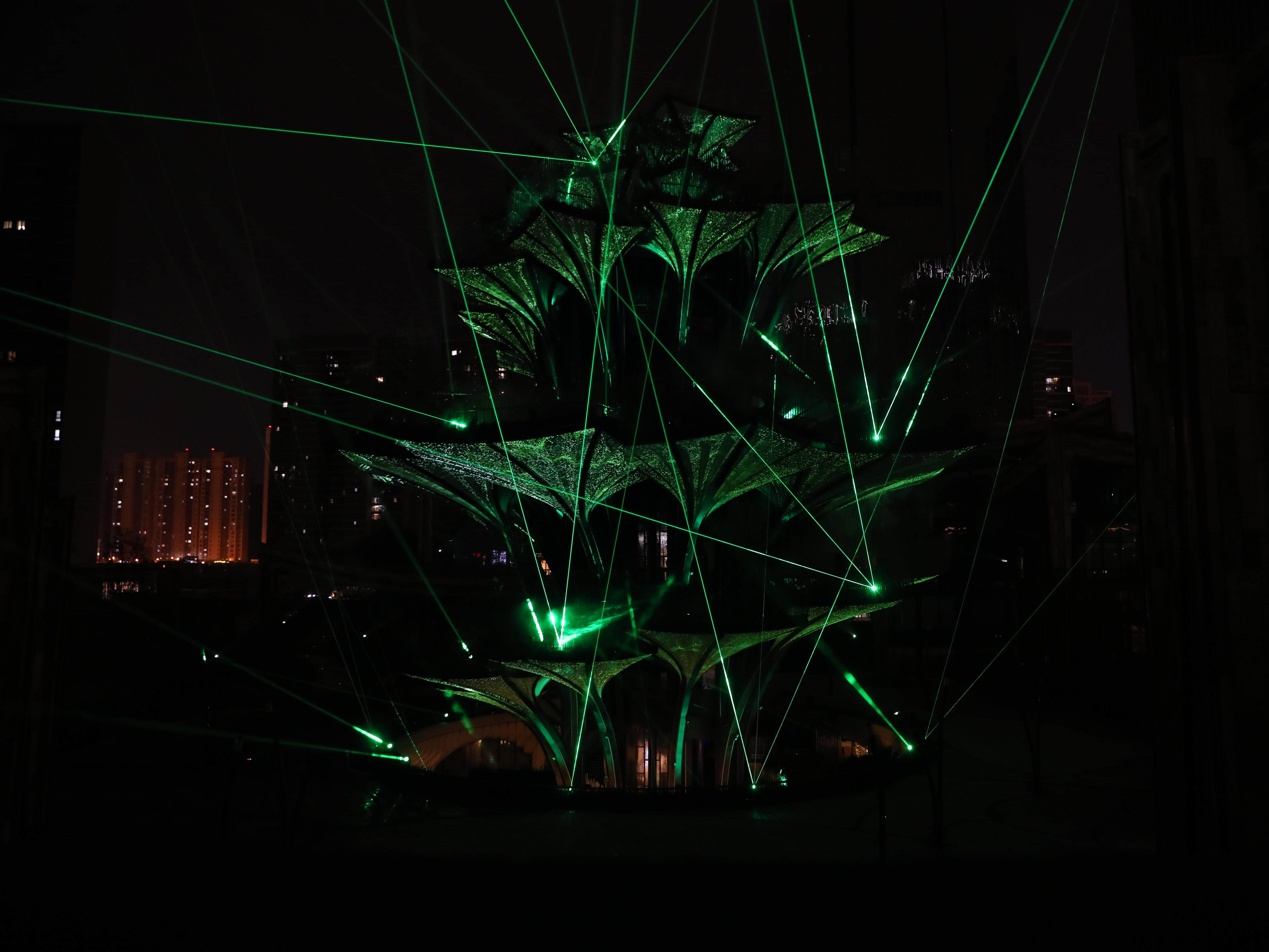 Purple laser beams creating intersecting patterns around the Tree of Life landmark installation in Xi'an, China Purple laser beams creating intersecting patterns around the Tree of Life landmark installation in Xi'an, China